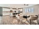 Bright, open concept living room and kitchen, featuring hardwood floors, white cabinets, and modern furnishings at 6233 Canterbury Field Rd, Las Vegas, NV 89113