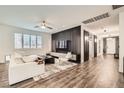 Modern living room with a stylish accent wall, hardwood floors, and contemporary furnishings and decor at 6233 Canterbury Field Rd, Las Vegas, NV 89113