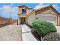 Tan two story home with a two car garage and desert landscaping at 6678 Crystal Run Ln, Las Vegas, NV 89122