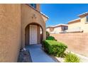 Inviting arched front entry with a decorative security door and lush landscaping at 7652 Silver Baron Rd, Las Vegas, NV 89179