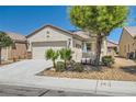 Inviting single-story home with desert landscaping, a two-car garage, and a quaint front porch at 7717 Pine Warbler Way, North Las Vegas, NV 89084