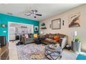 Comfortable living room with stylish decor, including a colorful rug, decorative shelves, and a modern ceiling fan at 7717 Pine Warbler Way, North Las Vegas, NV 89084