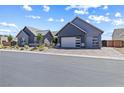 A modern gray home showcasing a paved driveway leading to a garage with unique glass panels at 8840 Harvest Sunset St, Las Vegas, NV 89113