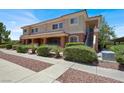 Exterior view of a two-story condo featuring a covered porch and well-maintained landscaping at 10553 Pine Glen Ave # 101, Las Vegas, NV 89144