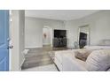 Open-concept living room featuring modern decor, hard flooring and a large couch at 10553 Pine Glen Ave # 101, Las Vegas, NV 89144
