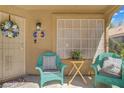 Cozy front porch with teal wicker chairs, creating a welcoming entry at 1604 Imperial Cup Dr, Las Vegas, NV 89117