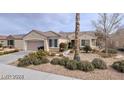 Single-story home showcasing beautiful landscaping with rock and mature desert plants at 1652 Black Fox Canyon Rd, Henderson, NV 89052