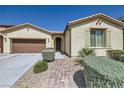 Inviting single-story home with decorative shrubs, a tile roof, and an attached two-car garage at 1792 Gentle Brook St, North Las Vegas, NV 89084