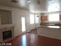 Open-concept living room with a fireplace, hardwood floors, and views into the kitchen and backyard at 256 Camino Viejo St, Henderson, NV 89012