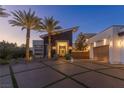 Nighttime shot of a modern home featuring a landscaped front yard and stylish design at 2610 Eldora Estates Ct, Las Vegas, NV 89117