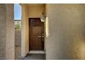 Close-up of a dark brown front door with a decorative lantern and neutral stucco exterior at 3002 Coveri Ct, Las Vegas, NV 89141