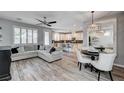 Open-concept living room with wood floors, a gray sofa, and seamless transition to a modern kitchen at 3002 Coveri Ct, Las Vegas, NV 89141