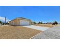 Side view of home exterior showcasing well maintained yard and driveway at 3016 Mount Charleston Dr, Pahrump, NV 89048