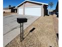 Suburban home with a two-car garage, low-maintenance desert landscaping, and a sunny, open driveway at 3318 Covey Ln, Las Vegas, NV 89115