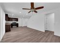 Open floor plan features modern kitchen with stainless appliances, spacious living area with ceiling fan, and vinyl floors at 3677 Via El Monte Ave, Las Vegas, NV 89115