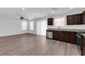 Open-concept kitchen and living area with stainless steel appliances, granite countertops, and modern vinyl flooring at 3677 Via El Monte Ave, Las Vegas, NV 89115