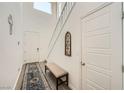 Bright foyer features a staircase, a neutral bench, and wood-look flooring, creating an inviting entrance at 4364 Contour Bend Ave, North Las Vegas, NV 89084