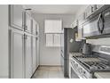 Kitchen with tiled floors, white cabinets, black hardware, and stainless steel appliances at 5324 Pendergrass St, North Las Vegas, NV 89081