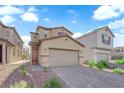 Two-story home with two car garage and desert landscaping in front yard for minimal upkeep at 5677 Asyma Ct, Las Vegas, NV 89113