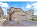 Two-story home featuring a two car garage, desert landscaping, and covered front entryway at 5677 Asyma Ct, Las Vegas, NV 89113