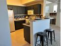 Cozy kitchen featuring sleek dark cabinets, a breakfast bar with stools, and modern appliances at 5855 Valley Dr # 2092, North Las Vegas, NV 89031
