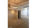 Neutral dining room featuring modern chandelier, paneled walls, carpet, tile, and open concept design at 6245 Hawthorn Woods Ave, Las Vegas, NV 89130