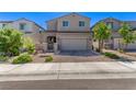Inviting home with a two-car garage, complemented by a brick driveway and mature landscaping at 6313 Voss St, North Las Vegas, NV 89081