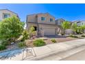 Well-kept home featuring a two-car garage, brick-paved driveway, and lush landscaping in the front yard at 6313 Voss St, North Las Vegas, NV 89081