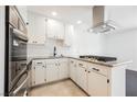 Updated kitchen with stainless appliances, white cabinets and granite counters, and tile flooring at 6330 Spring Meadow Dr, Las Vegas, NV 89103