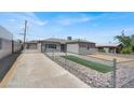 View of driveway leading to home featuring xeriscaping, fenced yard, and neutral paint at 636 Burton St, Henderson, NV 89015