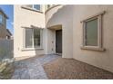 Inviting front entrance with paver walkway, desert landscaping, a black front door, and modern window trim at 6486 Vanhoven Crest St, Las Vegas, NV 89166