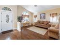 Bright living room with hardwood floors, large arched window, and comfortable seating at 672 Hitchen Post Dr, Henderson, NV 89011