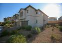 Two-story home with a two-car garage, desert landscaping, and a paver driveway at 7037 Tilligerry St, North Las Vegas, NV 89084