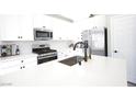 Modern kitchen with white cabinets, stainless steel appliances, and a quartz countertop island at 7037 Tilligerry St, North Las Vegas, NV 89084