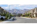 Neighborhood street view with houses and cars, with mountains visible in the distance at 7037 Tilligerry St, North Las Vegas, NV 89084