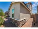 Exterior facade showcasing the stone accents, brick paver walkway, and stucco exterior of the home at 7124 Sayonara Vista St, North Las Vegas, NV 89084