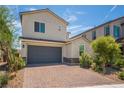 Charming two-story home with a two car garage and a brick paver driveway, surrounded by well-maintained landscaping at 7124 Sayonara Vista St, North Las Vegas, NV 89084