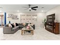 Spacious living room with a comfortable sectional sofa and a large windows for natural light at 7502 Lush Oasis Ave, Las Vegas, NV 89113