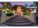 Beautiful home with an arched entryway and steps to the front door, professionally landscaped with manicured shrubs at 761 Romano Ln, Henderson, NV 89012