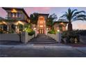 Beautiful home with an arched entryway, steps to the front door, and professionally landscaped front yard at twilight at 761 Romano Ln, Henderson, NV 89012