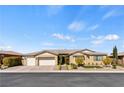 Inviting single-story home with a neutral color palette, three-car garage, and well-manicured front yard at 9240 Northfield Park Ct, Las Vegas, NV 89148