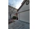 View of the two-car garage on a two-story home with neutral stucco exterior at 9617 Pine River Ln, Las Vegas, NV 89123