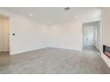 An open living room features hard flooring, recessed lighting, and a modern fireplace at 107 Barkset Way, Henderson, NV 89011