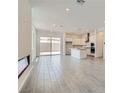A spacious living room boasts tile flooring, recessed lighting, and sliding doors leading to the outdoor patio at 107 Barkset Way, Henderson, NV 89011