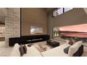 A modern living room with a fireplace, a TV, a large sofa, and a view of the water at 1516 Pleasant Bay Ct, Henderson, NV 89011