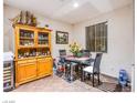 A charming dining area featuring a glass-top table with black chairs, complemented by a wood china cabinet at 1557 Blue Sierra Ct, Henderson, NV 89074