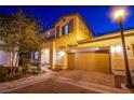 Two-story home with a brick driveway, a two-car garage, shutters, and a manicured front yard at 1557 Blue Sierra Ct, Henderson, NV 89074
