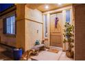 Inviting front porch with a decorative wreath, potted plants, and bench with decorative items at 1557 Blue Sierra Ct, Henderson, NV 89074