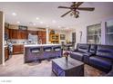 Open kitchen/living area features dark wood cabinets, stainless appliances, quartz island with bar seating, and comfortable seating at 1557 Blue Sierra Ct, Henderson, NV 89074