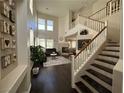Bright living room featuring high ceilings, a fireplace, hardwood floors, and a staircase at 1812 Warrenville St, Las Vegas, NV 89117